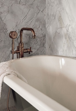 Ściany łazienkowe wyłożone spiekiem  Alexandra w jasnym, kremowo-beżowym odcieniu z wyrazistym, złocisto-szarym użyleniem.