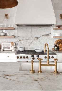 Kuchnia - ściany i blaty robocze, pokryte spiekiem Himalaya Crystal o jasnej tonacji z subtelnym, linearnym wzorem.