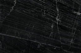 Oihana to kamień naturalny o głębokiej czerni, ozdobionej dynamicznymi, białymi żyłkami i subtelnymi złotymi drobinami