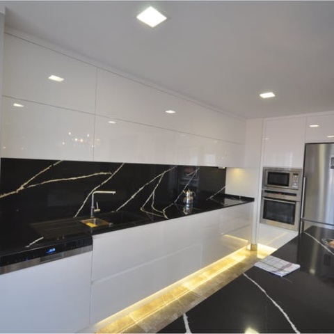 Et Marquina to elegancki czarny spiek kwarcowy. Zastosowanie jako czana ściana pomiędzy białymi meblami kuchennymi
