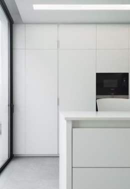 Meble kuchenne i blat wyspy pokryte spiekiem Arctic White o kolorze lodowej bieli.