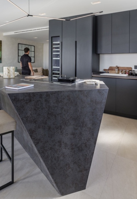 Wyspa kuchenna pokryta spiekiem Iron Grey – grafitowo-metaliczny odcień z subtelną strukturą przypominającą postarzałą stal.