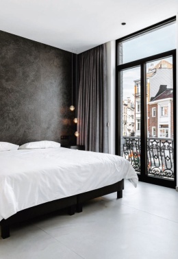 Ściana w sypialni wykonana z ciemnego spieku kwarcowego inspirowanego naturalnym kamieniem wulkanicznym - KRATER