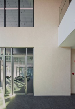 Elewacja pokryta okładziną ścienną wykonaną  ze spieku  Pietra di Osso - płyta o neutralnej, beżowo-szarej kolorystyce.