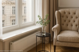 Parapet z konglomeratu kwarcytowego SiQuartz Crystal White w eleganckim salonie z oknem, fotelami i jasnym wnętrzem.