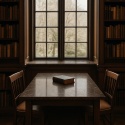 Zabytkowa biblioteka z dużym stołem z konglomeratu Santamargherita Libeccio i klasycznym oknem w tle.