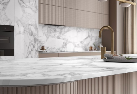 Detal blatu i ściany kuchennej w wykończeniu Calacatta Magnifico z elegancką armaturą.