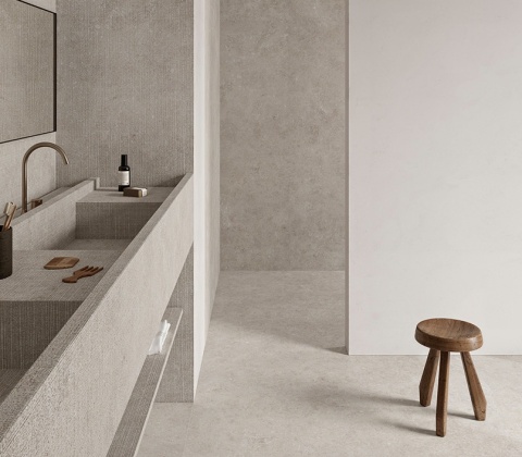 Minimalistyczna łazienka z umywalką i podłogą wykończoną spiekiem Infinity Arkeon Fossil  w jasnoszarej tonacji.