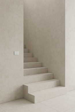 Nowoczesne schody wewnętrzne wykończone spiekiem Infinity Arkeon Fossil Matte w jasnoszarej, betonowej kolorystyce.