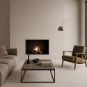 Minimalistyczny salon z kominkiem obudowanym spiekiem Infinity Arkeon Fossil Tartan Matte w jasnoszarej tonacji.