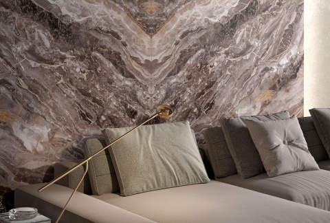 Elegancki salon z sofą na tle dekoracyjnej ściany z płyt Infinity MB19 Orobico Luxe w brązowych i złotych tonach.