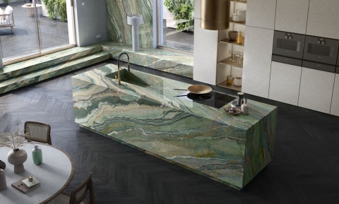 Kuchnia z wyspą pokrytą spiekiem Infinity MB20 Royal Peacock w zielono-złotych tonach.