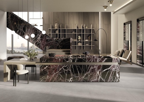 Elegancka kuchnia z wyspą wykończoną spiekiem Rosso Domus i drewnianymi akcentami.