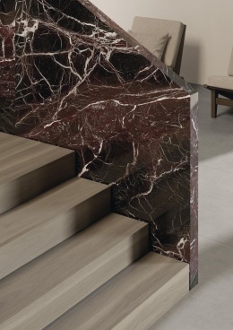 Schody z balustradą obłożoną spiekiem Rosso Domus w czerwono-czarnych odcieniach.