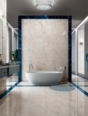 Luksusowa łazienka z wolnostojącą wanną i ścianami wykończonymi spiekiem Infinity Crystal Ice z ciemnoniebieskimi akcentami.