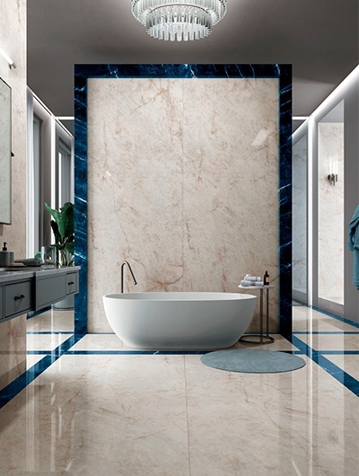 Luksusowa łazienka z wolnostojącą wanną i ścianami wykończonymi spiekiem Infinity Crystal Ice z ciemnoniebieskimi akcentami.