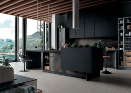 Nowoczesna kuchnia z wyspą i blatami ze spieku Nero Granite SE05, w industrialnym stylu z widokiem na góry.