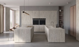 Kuchnia z wyspą i zabudową ze spieku Travertino Chiaro w stylu nowoczesnym.
