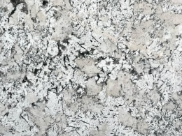 Zbliżenie powierzchni granitu Andorra – białe i szare kryształy z kontrastującymi ciemnymi akcentami.