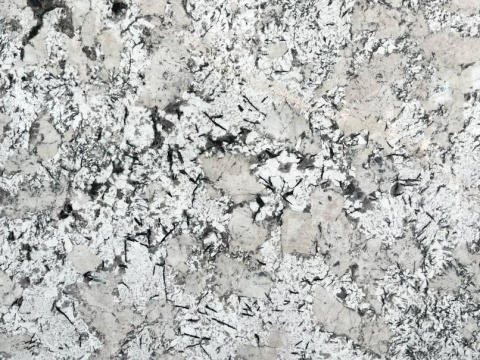 Zbliżenie powierzchni granitu Andorra – białe i szare kryształy z kontrastującymi ciemnymi akcentami.