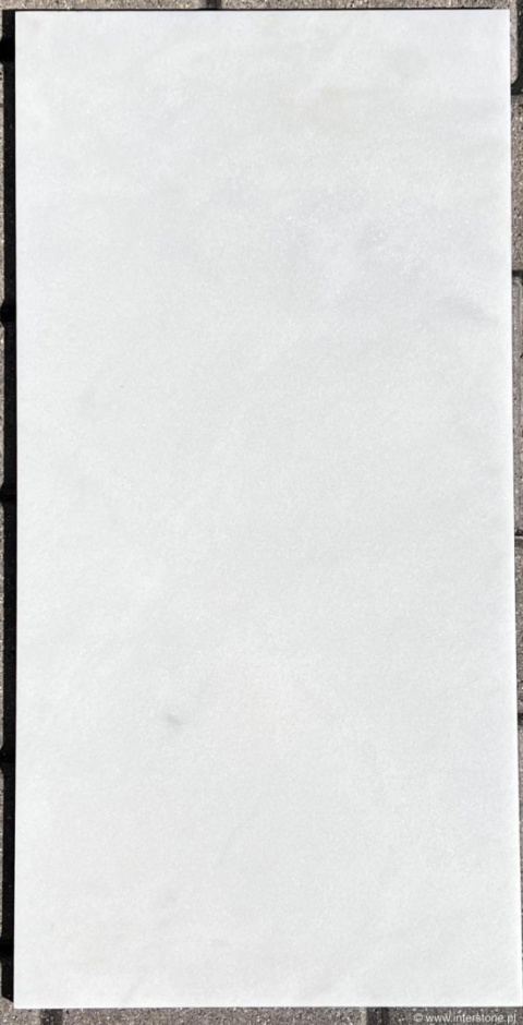 Płyta marmuru Alpine White w jednolitym białym odcieniu, gładka powierzchnia polerowana.