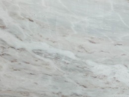 Zbliżenie marmuru Alpine White – jasna powierzchnia z delikatnym żyłkowaniem w szarych i beżowych tonach