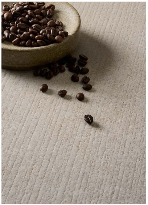 Powierzchnia spieku Infinity Arkeon Fossil Row Matte z fakturą rowków, na której leżą ziarna kawy.