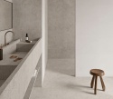 Minimalistyczna łazienka z umywalką i podłogą wykończoną spiekiem Infinity Arkeon Fossil  Row Matte w jasnoszarej tonacji