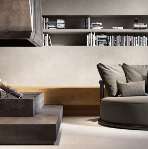 Nowoczesne wnętrze z kominkiem obudowanym spiekiem Infinity Metal Dark i sofą w neutralnych barwach.