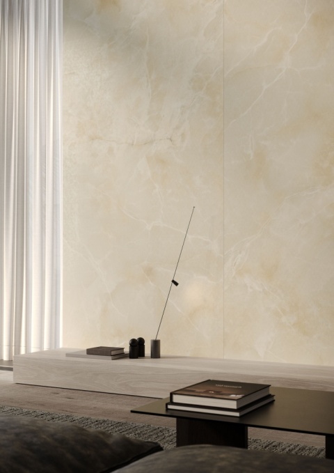 Salon z dekoracyjną ścianą wyłożoną płytami Laminam Lamborghini Tumultus w kremowo–beżowej tonacji