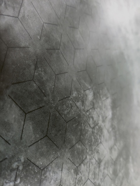 Zbliżenie faktury Laminam Lamborghini Tempestas z geometrycznym wzorem i ciemnym kamiennym wykończeniem