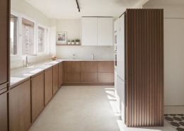 nowoczesna kuchnia z długim blatem Silestone Blanco Zeus i jasnymi drewnianymi szafkami.