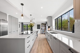 Nowoczesna kuchnia w odcieniach szarości z wyspą i blatami Silestone Eclectic Pearl o delikatnym żyłkowaniu.