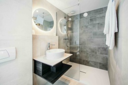 Silestone Gris Expo to szary spiek kwarcowy o ziarnistej fakturze ściany łazienkowe.