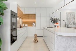 Nowoczesna kuchnia z wyspą, drewnianymi akcentami i jasnym blatem Silestone Nolita.