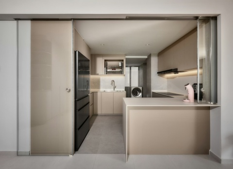 Jasna kuchnia z beżowymi frontami i wyspą wykończoną spiekiem kwarcowym Dekton Albarium.