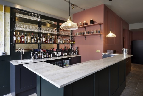 Restauracyjny bar z szerokim blatem z Dekton Arga w jasnym, naturalnym odcieniu.