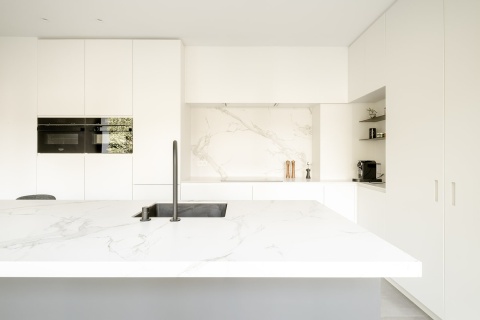 Jasna nowoczesna kuchnia z wyspą i blatem wykonanym z Dekton Aura KC w matowym wykończeniu