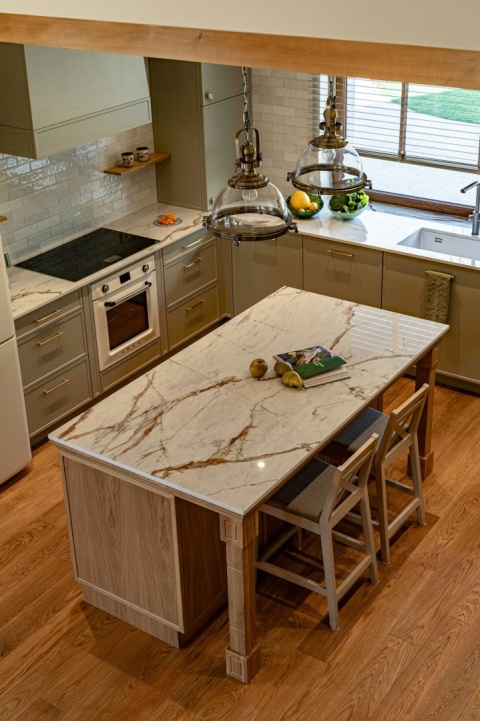 Wyspa kuchenna z blatem Dekton Onirika Awake w wykończeniu x-gloss, otoczona klasycznymi szafkami.