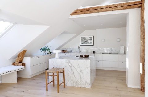 Nowoczesna jadalnia z Dekton Bergen – duży stół wykończony błyszczącą powierzchnią imitującą marmur.