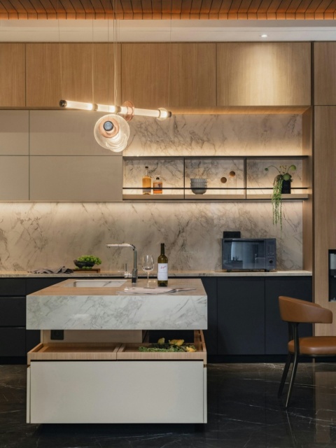 Kuchnia projektowa z Bergen na ścianach – jasne wnętrze z akcentami drewna i marmurowym dektonem.