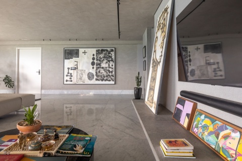 Salon, w którym płyty Dekton Kreta zastosowano na podłodze i meblach, łącząc subtelną szarość z designerskim wyposażeniem.