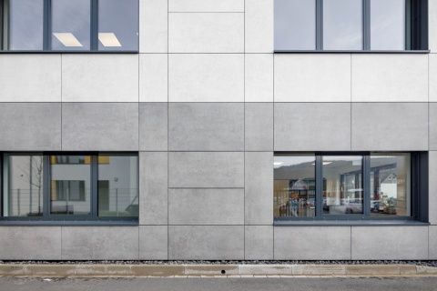 elewacja budynku z zastosowaniem płyt Dekton Kreta w systemie fasadowym, tworząca jednolitą szarość z industrialnym charakterem.