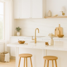 Jasna kuchnia z dużym oknem, ściany wykończone spiekiem Dekton Limbo KC, naturalne drewno i delikatne dodatki.