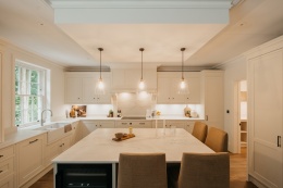 Luksusowa kuchnia w rezydencji z dużą wyspą pokrytą spiekiem Dekton Lucid w wykończeniu polerowanym.