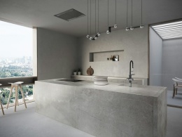 Minimalistyczna kuchnia z wyspą wykończoną spiekiem Dekton Soke w matowym szarym odcieniu.