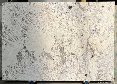 jasne tło z delikatnymi szaro-beżowymi smugami i subtelnymi akcentami mineralnymi.