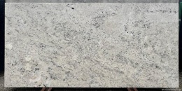 powierzchnia Colonial White z dominującą jasną bazą i delikatnymi żyłkami mineralnymi, w wersji polerowanej.