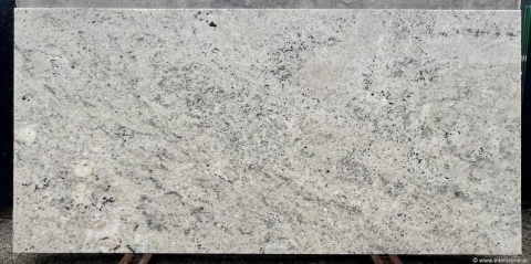 powierzchnia Colonial White z dominującą jasną bazą i delikatnymi żyłkami mineralnymi, w wersji polerowanej.