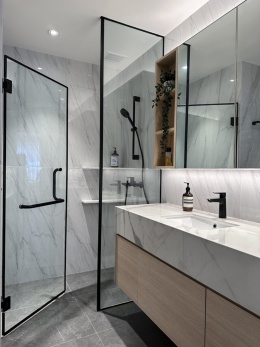 Łazienka z prysznicem i umywalką wykończoną płytami Dekton Vigil kC w polerze.